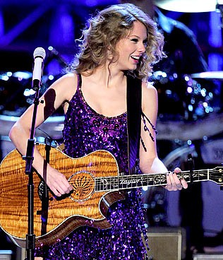 EUA - 0h12 - A cantora Taylor Swift sobe ao palco do Brooks & Dun