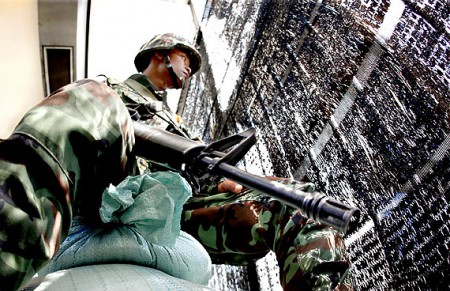Tailândia - 2h36 - Um soldado do exército tailandês vigia o protesto anti-governo dos "camisas vermelhas" reunidos em um cruzamento próximo a uma estação do Skytrain em Bangcoc.